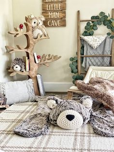 a teddy bear laying on top of a bed next to a wooden sign that says love's little man cave