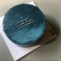 a blue birthday cake with stars and the words happy birthday on it's side