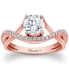 a rose gold engagement ring with an oval cut diamond in the center and two rows of diamonds on each band