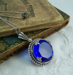 Sapphire Necklace Dark Blue Faceted Stone by CreatedinTheWoods Victorian Blue Gemstone Necklace, Vintage Round Sapphire Jewelry, Formal Blue Locket Jewelry, Blue Round Pendant Locket Jewelry, Victorian Sapphire Round Jewelry, Blue Round Faceted Jewelry, Blue Faceted Round Jewelry, Victorian Round Faceted Jewelry, Victorian Faceted Round Jewelry