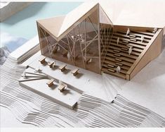 an architectural model of a building with people standing outside and on the ground next to it