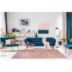 a living room with blue couches and pink rugs on the floor in front of a bookshelf