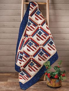 an american flag quilt on a chair next to a potted plant