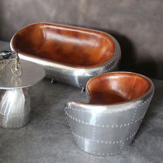 two silver and brown chairs sitting next to each other on top of a gray floor