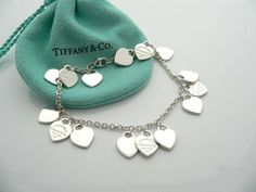 Overview:Offered for sale is a wonderful and gorgeous and rare Return to Tiffany & Co. Multi Hearts Dangle Charm bracelet.  Definitely a Tiffany piece that you will get your money's value for.  It works perfectly with pretty much any attire your put on, AND is an awesome statement piece.   Very pretty and unique piece!  It is the perfect bracelet that fits a lifestyle on the go -- the piece can be worn to pretty much any occasion!  It is simple, elegant, and classic all rolled into one neckl Luxury Sterling Silver Heart Charm Jewelry, Pink Tiffany And Co Charms, Luxury Sterling Silver Bracelets For Valentine's Day, Luxury Silver Bracelets For Valentine's Day, Luxury White Gold Bracelet With Heart Charm, Luxury Wedding Heart Bracelet With Heart Charm, Luxury Sterling Silver Heart Bracelet For Valentine's Day, Aaa Quality Dangle Jewelry For Gifts, Luxury Valentine's Day Charm Bracelet