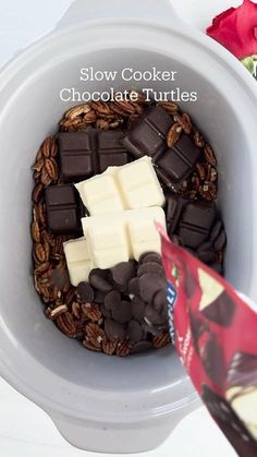 a bowl filled with chocolate and marshmallows on top of a white table