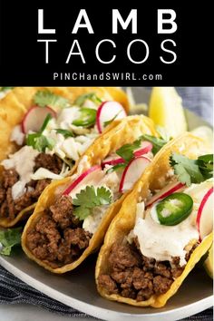 three tacos on a plate with limes and cilantro garnishes