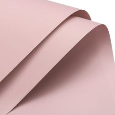 a pink sheet of paper folded in half on top of each other with the end rolled up