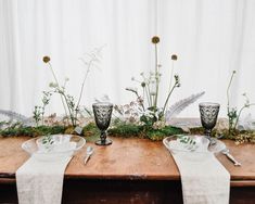 the table is set with silverware and flowers