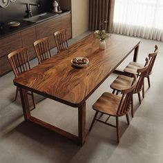 a dining room table with six chairs and a bowl of fruit on the counter top