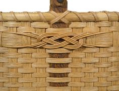 a close up of a woven basket with wood handles