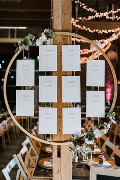 a table set up with place cards and flowers on it for a wedding reception at the barn