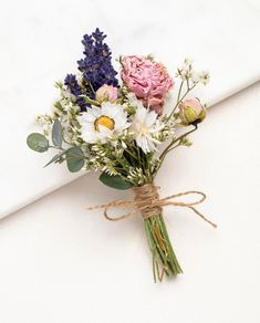 a bouquet of flowers tied to a white surface