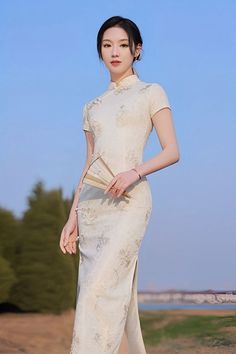 A beautiful woman in a long white qipao Chinese dress with short sleeves Elegant White Cheongsam For Spring, Elegant Beige High Neck Dress, Elegant High Neck Beige Dress, Elegant Beige Dress With Stand Collar, Elegant White High Neck Maxi Dress, White Fitted Cheongsam With Stand Collar, Elegant White Ao Dai For Formal Occasions, White Cheongsam With Short Sleeves, Elegant Formal Ao Dai Maxi Length