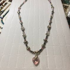 This necklace is a blend of silver alloy hearts, flowers and butterflies mixed with silver and pink crystal beads. The centerpiece, a beautifully polished heart-shaped pink crystal pendant, that radiates an array of colors that dance in the light. Each bead and charm is meticulously arranged to create not just a piece of jewelry but a work of art that graces the neckline. Materials: Silver butterfly, flower and heart beads Heart-shaped gemstone pendant Dimensions: Necklace Length: 18 inches Pendant Size: 1 inch Lobster clasp Silver Heart Crystal Necklace, Pink Beaded Heart Pendant Necklace, Pink Beaded Heart Pendant Jewelry, Pink Beaded Necklace With Heart Pendant As Gift, Pink Heart Pendant Beaded Necklace As Gift, Pink Heart Pendant Beaded Necklace For Gift, Pink Heart Pendant Beaded Necklace For Valentine's Day, Pink Crystal Heart Pendant Jewelry, Elegant Pink Heart Necklace With Heart Beads