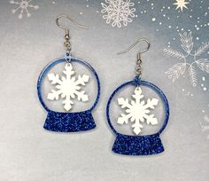 the snowflake earrings are made from blue glitter and have white frosting on them