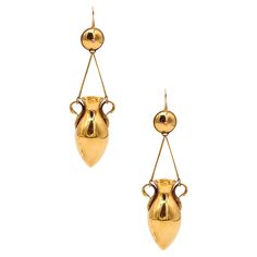 Etruscan-Roman revival ear drops pendants. Magnificent oversized drop earrings, from the Victorian Era (1837-1901) circa 1880. These beautiful pair has been crafted with etruscan-roman revival patterns in solid yellow gold of 18 karats, with high polished finish. The main elements are two conical amphorae with swan-shaped handles. These hang from two straight tensors attached to a round element simulating a shield. They are suited with hinged flexibles French hooks for pierced. These extraordina Etruscan Jewelry, Ear Drops, The Victorian Era, Garnet And Gold, Art And Craft Design, Design Movements, Prince Albert, Colored Gems, Victorian Era