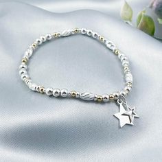 This dainty, sparkling sterling silver and 14k gold-filled stretch bracelet featuring two beautiful star charms is the perfect piece of jewellery for lovers of both silver and gold jewellery and all things celestial  The bracelet looks stunning as a stand-alone piece or can be stacked alongside other bracelets to create a more Bohemian feel The eclectic mix of the highest-quality sterling silver and gold-filled beads are stung onto very strong, professional grade jewellers' elastic, meaning there are no fiddly clasps to deal with, simply roll the bracelet over your hand and onto your wrist Sterling silver is a precious metal known for its durability, luster and resistance to tarnish The bracelet comes presented in a beautiful grey faux suede jewellery pouch along with aftercare instruction Silver Beaded Bracelet With Star Charm As Gift, Silver Beaded Bracelet With Star Charm For Gift, Silver Beaded Bracelets With Star Charm As Gift, Celestial Bracelet, Silver And Gold Jewellery, Bracelet Star, Suede Jewelry, Jewellery Pouch, Star Bracelet