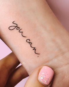 a woman's foot with the word love tattooed on her left ankle and pink nail polish