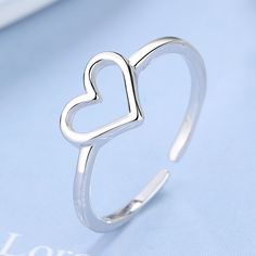 The Sterling Silver Minimalist Heart Ring is a simple yet elegant piece of jewelry that captures the essence of minimalism and sophistication. This ring features a delicate and minimalist heart design, crafted from high-quality sterling silver. The design of the Sterling Silver Minimalist Heart Ring is inspired by simplicity and clean lines, making it a perfect choice for those who appreciate the beauty of minimalism. The heart design is small and understated, yet it still manages to convey a me Silver Toe Rings, Chic Look, Personalized Accessories, Toe Rings, Sterling Silver Heart, Boho Rings, Perfect Ring, Heart Design, Silver Heart