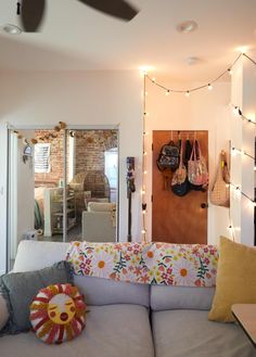 a living room filled with furniture and lots of lights on the wall above it's doorway