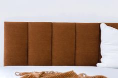 a brown headboard with white pillows on it