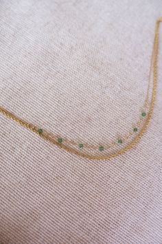 Elegant stainless steel necklace featuring a radiant golden finish and adorned with enchanting green pearls. This adjustable necklace offers versatility, allowing you to customize the length to suit your preference and style! Green Pearl Chain Jewelry As A Gift, Elegant Green Beaded Chain Necklace, Green Pearl Chain Necklace With Round Beads, Delicate Green Necklace With May Birthstone, Adjustable Green Metal Necklaces, Delicate Green May Birthstone Necklace, Green Jewelry With Round Beads And Adjustable Chain, Green Jewelry With Adjustable Chain And Round Beads, Green Beaded Chain Necklace As Gift