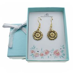 Our sunflower earrings are the perfect gift for any occasion! These earrings would make a wonderful Birthday, Christmas, Valentines Day, or anniversary gift for any special lady in your life! These cute earrings are made of 24K gold plated pewter on stainless steel wires. Stainless steel is a wonderful metal for earring wires because it is hypoallergenic and can be worn by most people. Size: one size.  Gender: female.  Age Group: adult. Metal Sunflower, Sunflower Charm, Sunflower Jewelry, Sunflower Gifts, Elastic Ribbon, Silver Ribbon, Sunflower Earrings, Earring Wires, Paper Gift Box