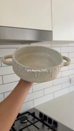 a person holding a pan over a stove top oven with the words diy baking dish on it