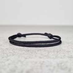 Simple black string bracelet, made from a nylon cord. The bracelet has an adjustable size thanks to the sliding knot. This a simple fabric jewelry that can be worn alone or stacked with other bracelets. Suitable for both men and women. The bracelet is fully water-resistant, so you can swim and shower with it. - - - - - - - - - - Materials: Nylon cord  - Cord diameter 2mm - Color: Black - - - - - - - - - Sizes: S - Fully Closed - 5.9"inches (15cm) / Full Opened - 11.8"inches (30cm) M - Fully Clos Casual Nylon Cord Friendship Bracelets With Adjustable Length, Adjustable Nylon Cord Friendship Bracelet, Casual Braided Bracelets With Sliding Knot, Everyday Black Bracelets With Nylon Cord, Black Nylon Cord Braided Bracelet For Everyday, Adjustable Nylon Cord Braided Bracelets For Everyday, Adjustable Nylon Cord Braided Bracelet, Casual Black Braided Bracelets For Friendship, Casual Black Braided Friendship Bracelets