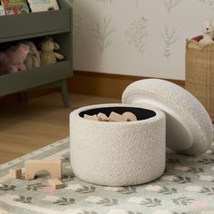 there is a white container on the floor next to a stuffed animal and bookcase