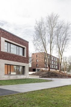 two brick buildings sitting next to each other on top of a grass covered park area