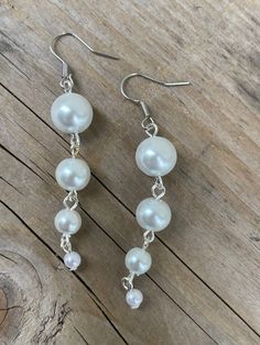 These earrings are made with white glass Pearl beads Handmade White Dangle Clip-on Earrings, White Dangle Crystal Earrings With Pearl Drop, White Beaded Clip-on Earrings For Party, White Pearl Crystal Earrings For Pierced Ears, White Pearl Crystal Earrings, Pearl White Round Beads Earrings, Pearl White Round Beaded Earrings, Pearl Beaded Drop Earrings For Pierced Ears, White Sterling Silver Chandelier Earrings For Party