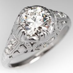 an antique style diamond ring with filigrees on the band and center stone