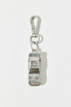 a silver charm with a small clock on it's side and a key chain attached to the clasp