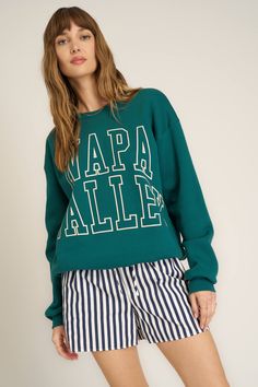 Napa Valley Arch Sweatshirt in Pacific Teal Fall Athleisure Sweater With Graphic Print, Collegiate Graphic Print Sweatshirt For Spring, Sporty Graphic Print Tops For The Weekend, Sporty Letter Print Tops For Weekend, Sporty Cotton Tops With Letter Print For Weekend, Sporty Weekend Tops With Letter Print, Sporty Tops With Letter Print For Weekend, Sporty Tops For Fall Weekend, Sporty Tops For Weekend Fall Season