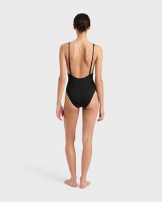 The Juliet One Piece in Black is a timeless and elegant swimsuit featuring a plunge V neckline. Adjustable, shoe-string straps combine with a low cut back to flatter and feature the beauty of the back. Juliet has a medium-high cut leg with regular bottom coverage. Juliet is crafted from our luxury Italian Singuleur® fabric which forms to the body like a second skin. Suitable for bust sizes A-C.Luxury fabric sustainably made in Italy. Elegant Swimsuit, Luxury Fabric, Deep Plunge, Plunge Neckline, Designer Swimwear, Cool Suits, Plunging Neckline, High Cut, Skin Protection