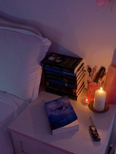 a night stand with books and candles on it