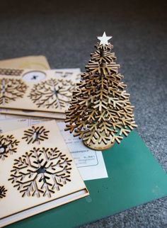 three wooden christmas trees sitting on top of cards