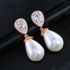 A classy and delicate pair of earrings perfect for the romantic bride, featuring pearls in an iridescent white color and clear cubic zirconia. Electroplated with noble metals (rhodium, 14K rose gold, and 14K yellow gold) for a flawless finish which perfectly enhances the intricate detailing and conveys a modern take on old elegance, these exquisite earrings will add a touch of sophistication to any wedding gown or formal ensemble. Length: 1.25" (approx. 3.2cm); Width: 0.4" (approx. 1cm); Weight: Elegant Bridal Earrings In Diamond White Cubic Zirconia, White Cubic Zirconia Crystal Earrings With Elegant Design, Pearl Drop Cubic Zirconia Earrings For Party, Teardrop Pearl Earrings With Cubic Zirconia For Party, Elegant Pearl Earrings With Cubic Zirconia, Elegant Diamond White Pearl Bridal Earrings, Pearl White Cubic Zirconia Pearl Earrings For Evening, Glamorous Cubic Zirconia Pearl Drop Jewelry, Pearl-embellished Cubic Zirconia Drop Earrings