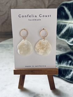 100% Handmade white jingle shells are arranged as beautiful drop earrings. They are very lightweight , great for all day wear. These nickel-free earrings feature gold-plated circle stud findings for comfort and simple aesthetic .  The shells for each pair are hand picked, and are meticulously assembled. These earrings have an organic and minimal look while still being very versatile. Would even make a beautiful addition to a beach bridal look. Please note,  each shell and by extension each pair have its own characteristics making them beautifully one of a kind . Bohemian White Mother Of Pearl Earrings, Cream Shell Jewelry For Gifts, Cream Shell Jewelry For Gift, Adjustable White Mother Of Pearl Earrings, White Teardrop Earrings For Beach, Bohemian White Shell Earrings, White Mother Of Pearl Jewelry For Vacation, White Shell Dangle Jewelry, White Drop Earrings For Beach