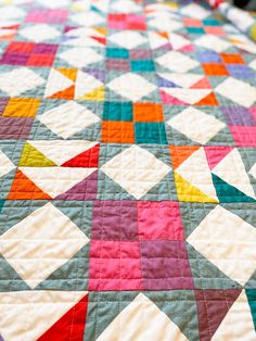 a colorful quilt is laying on the bed