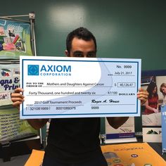 a man holding up a large check for $ 1, 000