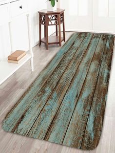 an old wooden floor rug with blue paint on the top and bottom, next to a table