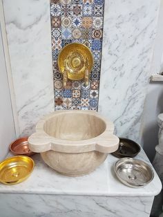 a white marble sink with gold faucet and matching bowls