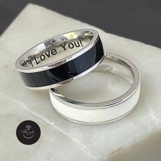 This stunning Personalized Tungsten Ring is truly a one-of-a-kind piece, featuring a Laser Engraved Secret Message that adds a special touch that uniquely expresses your love and appreciation. It makes for the Perfect Father's Day Gift for Dad, or for any gift-giving occasion. The Ring made from Best quality Stainless Steel and Available in two stylish Designs, choose between a sleek black with silver or an elegant white with silver finish. This ring is not only stylish and unique, but also carries a special message that will be cherished for years to come. Surprise your loved one with this meaningful and memorable gift today. ☻ STYLE: Men's Tungsten Ring ☻ MATERIALS: Stainless Steel ☻ RING WIDTH: 6mm / 0.25" ☻ THICKNESS: 1.5mm / 0.06" ☻ RING SIZE OPTIONS: (Us Size) 9,10,11 White Engraved Jewelry For Promise, White Engraved Promise Jewelry, Black Jewelry With Engraving Option For Anniversary, Personalized White Sterling Silver Couple Rings, White Symbolic Promise Ring, Symbolic White Promise Ring, Engraved Enamel Anniversary Ring, White Engraved Ring With Polished Finish For Gift, White Engraved Ring With Polished Finish As Gift