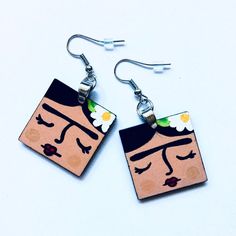 Experience the beauty of original wearable art with these Hand Painted Square Wooden Frida Earrings. Each pair is lovingly crafted by hand, from assembling the metal jump rings to carefully painting the intricate designs. No prints, only original artwork that showcases our passion and dedication. The high quality acrylic paint and protective gloss coat ensure these earrings are both stunning and durable. These one of a kind earrings are sure to make the perfect gift for that special someone in y Frida Earrings, Frida Kahlo Earrings, Mexican Jewelry, Intricate Designs, Button Pins, The High, Jump Rings, Clay Jewelry, Acrylic Paint