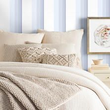 an image of a bedroom setting with blue and white stripes on the wall behind it