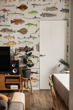 a living room filled with furniture and a wallpaper covered in different types of fish