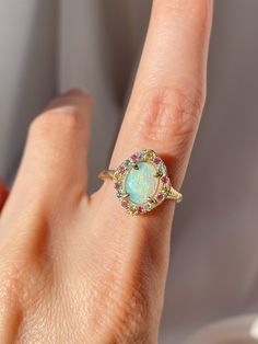 One of a kind 14k Yellow Gold Australian Opal Ring, enraptured by a dreamy pastel halo of Aquamarine, Pink Sapphires and Yellow Sapphires. 💌 Please write desired size (between 4-8) in *Notes* section at checkout Opal enhances cosmic consciousness and imparts mystical visions. Acting as a mirror, it reflects your thoughts and feelings back to you while shielding you as a karmic protector to deflect empathic emotions that are shone onto you by others. Opal is a teacher - amplifying our emotions s Multicolor Halo Jewelry For Wedding, Multicolor Halo Rings Fine Jewelry, Multicolor Oval Jewelry With Halo Setting, Multicolor Oval Halo Setting Jewelry, Fine Jewelry With Multicolor Halo, Oval Multicolor Jewelry With Halo Setting, Elegant Multicolor Opal Ring, Fine Multicolor Halo Jewelry, Multicolor Jewelry With Halo Setting For Wedding